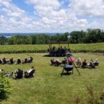 Live Music at Buttonwood Grove. patrons sitting in chairs in the lawn enjoying a band playing